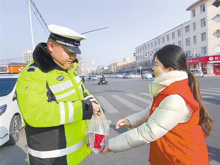 志愿者为交警送上热粥。 本报记者 王娜 摄