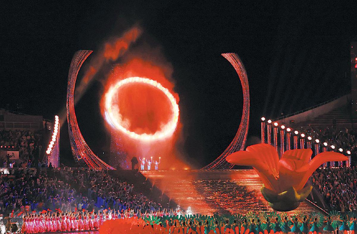 火炬手苏炳添、张家朗、李祎点燃主火炬后向观众致意。　新京报记者　王飞　摄