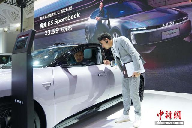 图为试乘汽车的市民与工作人员交流。中新社记者 刘冉阳 摄