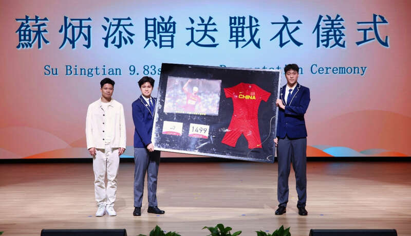 苏炳添（左一）将签名运动战衣赠予广州暨大港澳子弟学校。主办方供图
