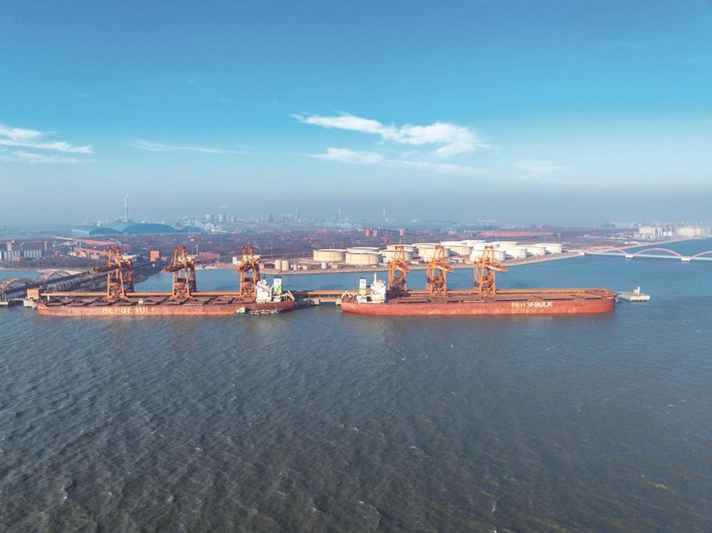 近日，在唐山港曹妃甸港区矿石码头，货船在装卸作业。 杨杨 摄