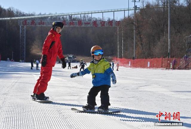 2025年11月21日，长春莲花山滑雪场“开板”迎客，一位小朋友在雪场教练指导下练习滑雪。(资料图) 张瑶 摄