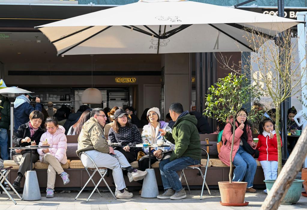 1月10日，市民游客在上海市徐汇区西岸梦中心一家商铺外享用甜品。新华社记者陈浩明摄