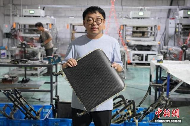 近日，邱东海介绍碳纤维轮椅零部件。董易鑫 摄