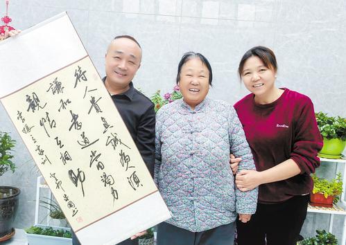11月7日上午，无极县大陈镇北家庄村村民李振立和母亲、妻子一起与家训条幅合影。本报记者 蔡晓辉摄