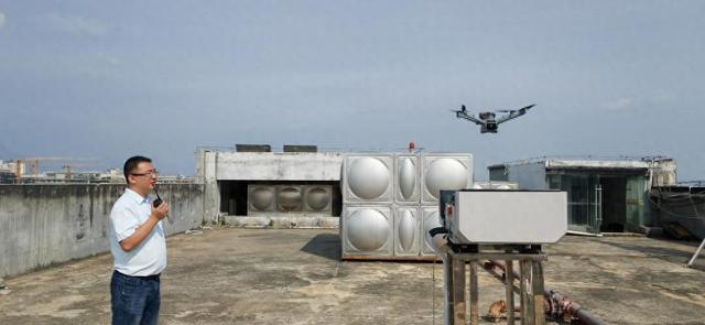 在蒙自市城区的一处楼顶，工作人员正在指挥远程操控无人机。新华社记者浦超 摄