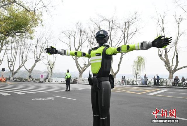 3月22日，AI交管机器人在西湖断桥马拉松赛道附近指挥交通。中新社记者 王刚 摄