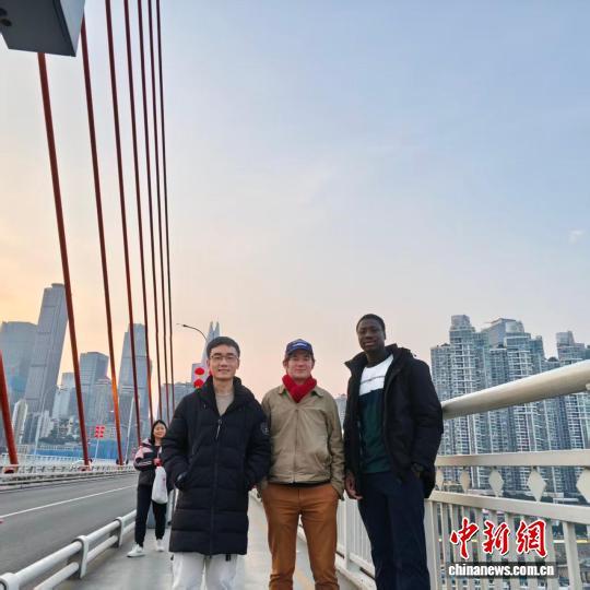 2025年，伊玛(右一)和友人在重庆千厮门嘉陵江大桥上合影。(受访者供图)