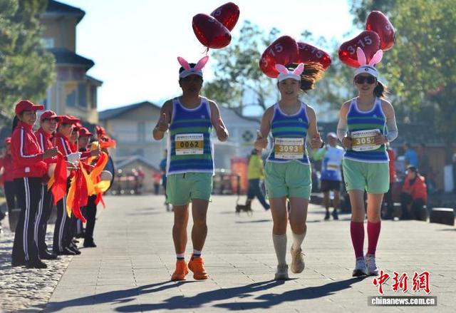 图为赛道上统一衣着、绑着写有时间气球的配速员吸引观赛者。中新社记者 张斌 摄