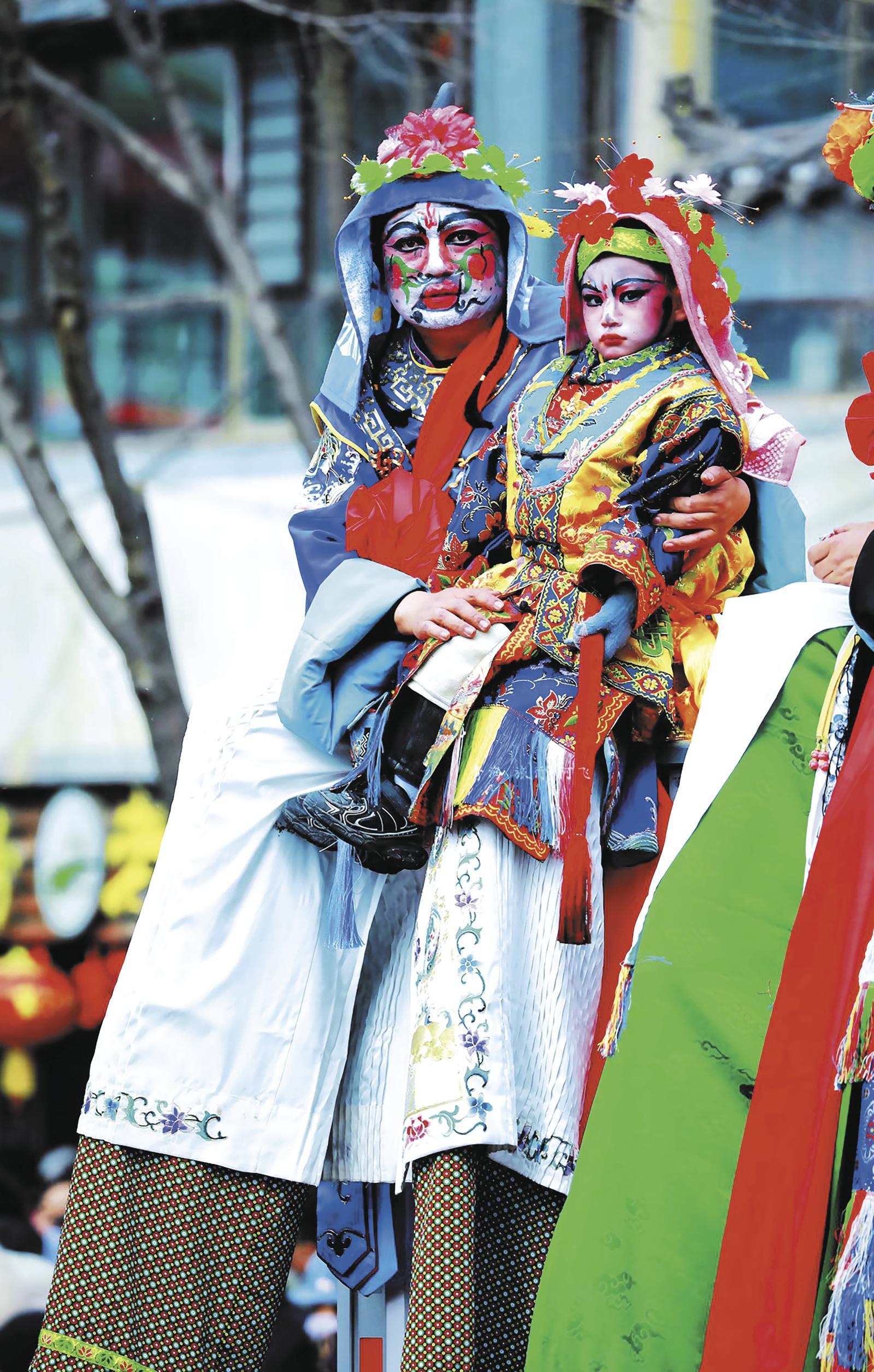 霍生军、霍启瑞父子同扮高跷角色“牛角”，儿子以父亲为榜样，传承同款扮相与技艺。霍生军 供图