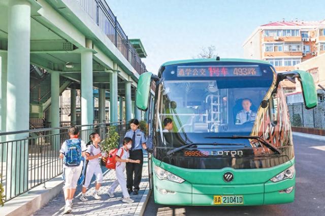 昨天下午，在北京育才学校新址，放学的学生在校内“公交站”登上通学公交。本报记者 邓伟摄