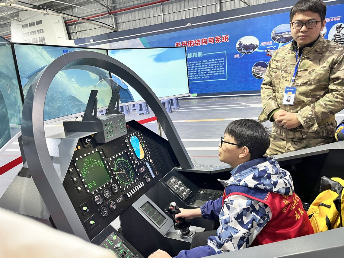     ▲“小记者”体验飞机在航母上着陆。    （本版图片除署名外均为本报记者佟镝 摄）