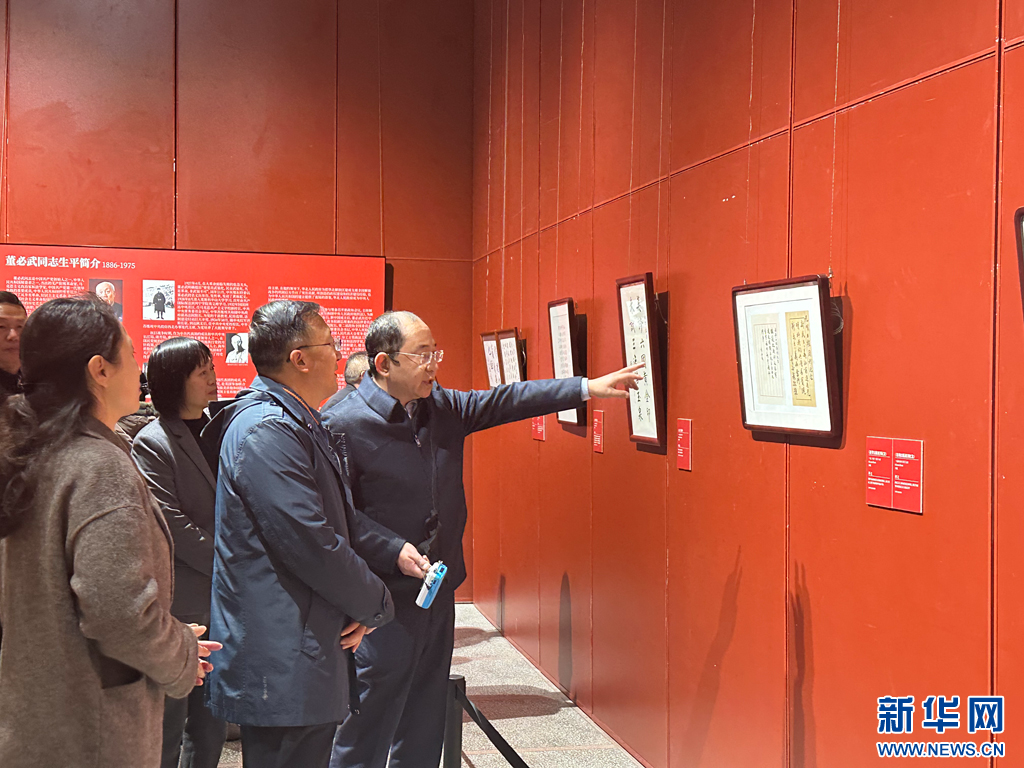 董必武之孙 董绍新为现场的嘉宾讲解董必武的手迹来源及故事（12月20日摄）。新华网发（王梓如 摄）