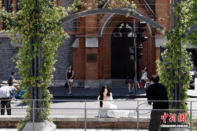 5月1日，游客在上海市黄浦区南苏州河路街头拍照，享受“五一”假期户外生活。中新社记者 殷立勤 摄