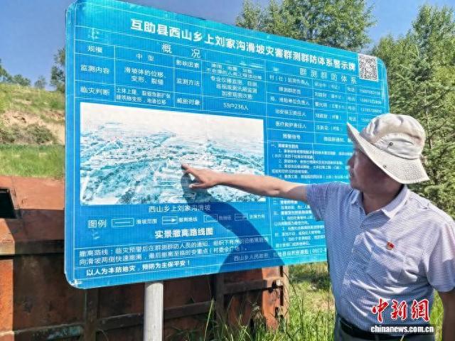 资料图为海东市互助县西山乡工作人员介绍滑坡灾害防治情况。李隽 摄