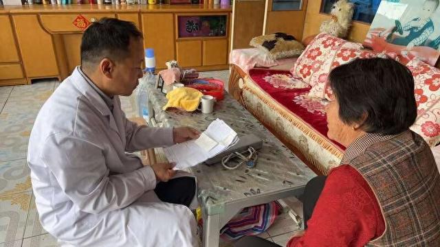 和林格尔县中蒙医院家庭医生王成亮给孟先花老人讲解体检报告。受访者供图