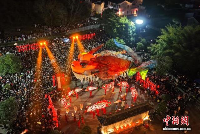 图为游客在欣赏“鳌鱼飞天”巡游表演。(无人机照片)施亚磊 摄