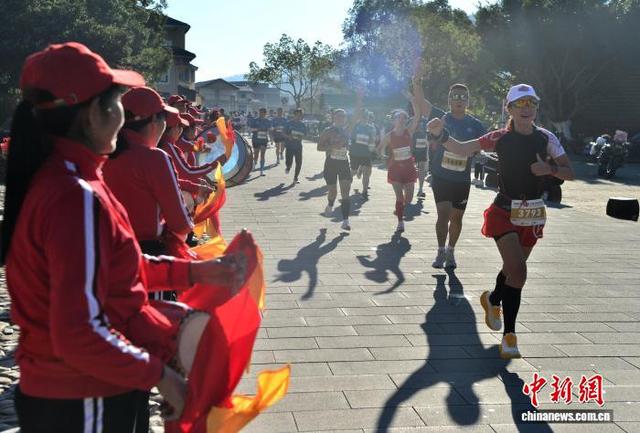 图为村民在赛道旁敲鼓为参赛选手加油助威。中新社记者 张斌 摄
