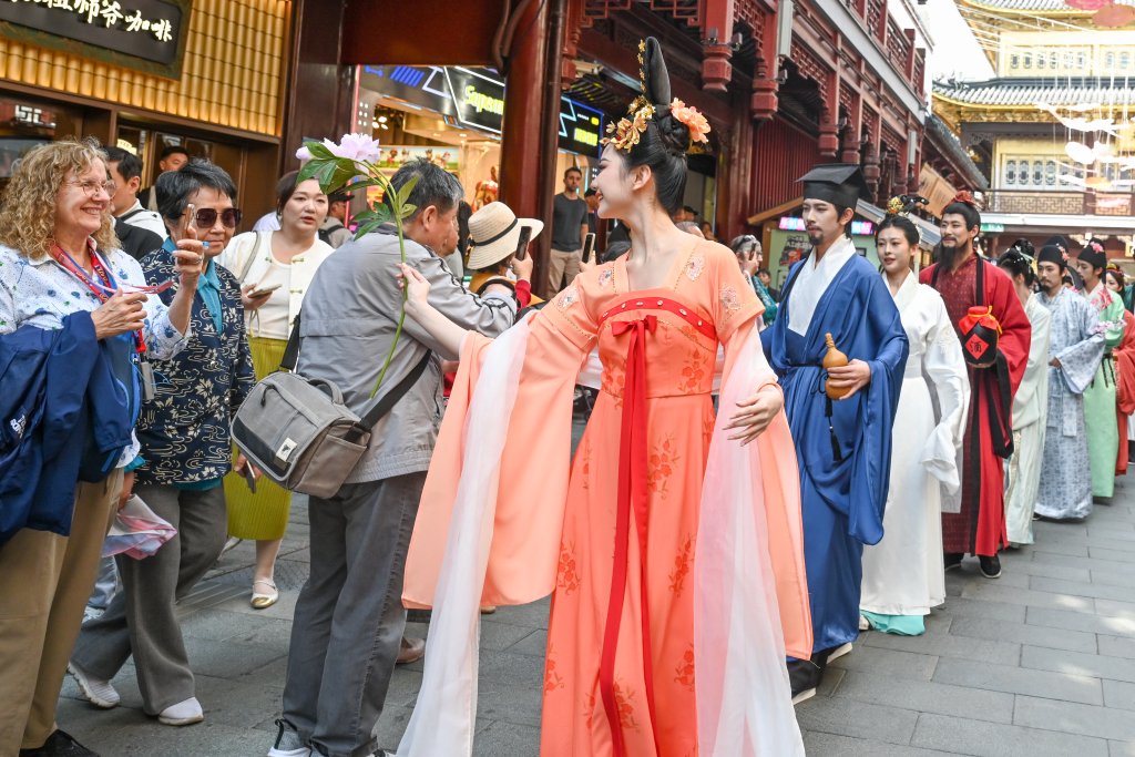 4月18日，上海豫园商城，花神和外国游客互动。澎湃新闻记者 朱伟辉 图