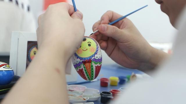 图说：监狱罪犯在研习蛋壳画。