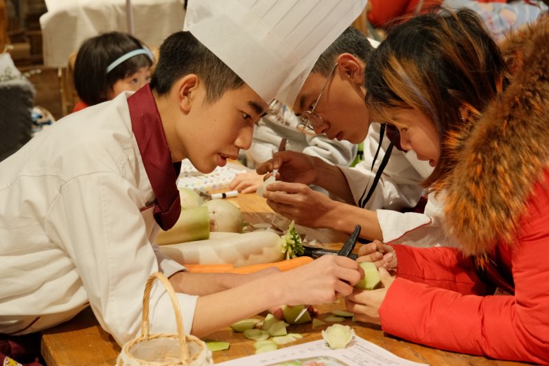 在李锦记希望厨师的指导下，居民们认真学习萝卜雕花技能