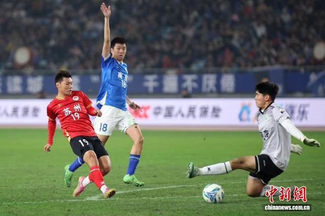 图为苏州队球员(红)在比赛中射门。中新社记者 泱波 摄