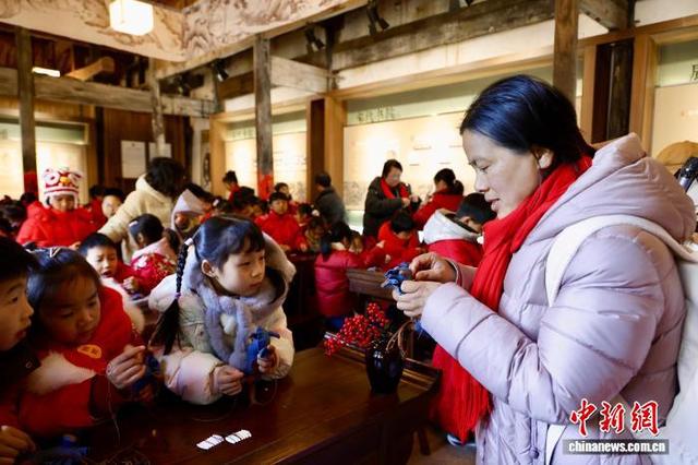 2月8日，浙江嵊州，学子在家长帮助下缝制布艺小马。中新社记者 肖健 摄