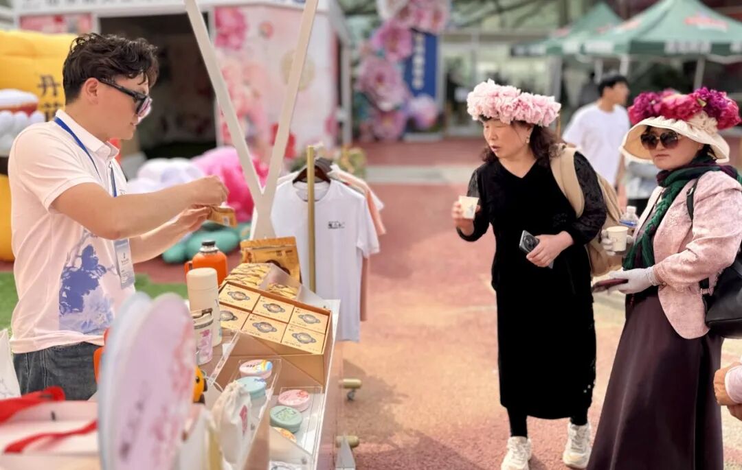 游客驻足了解牡丹系列衍生产品。图源：菏泽发布