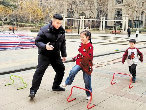 2月9日，石家庄市林荫大院小区，孙文（左）带孩子进行体能训练。本报记者 桑 珊摄