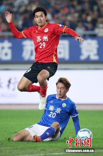 图为南京队球员(蓝)与苏州队球员(红)在比赛中拼抢。中新社记者 泱波 摄