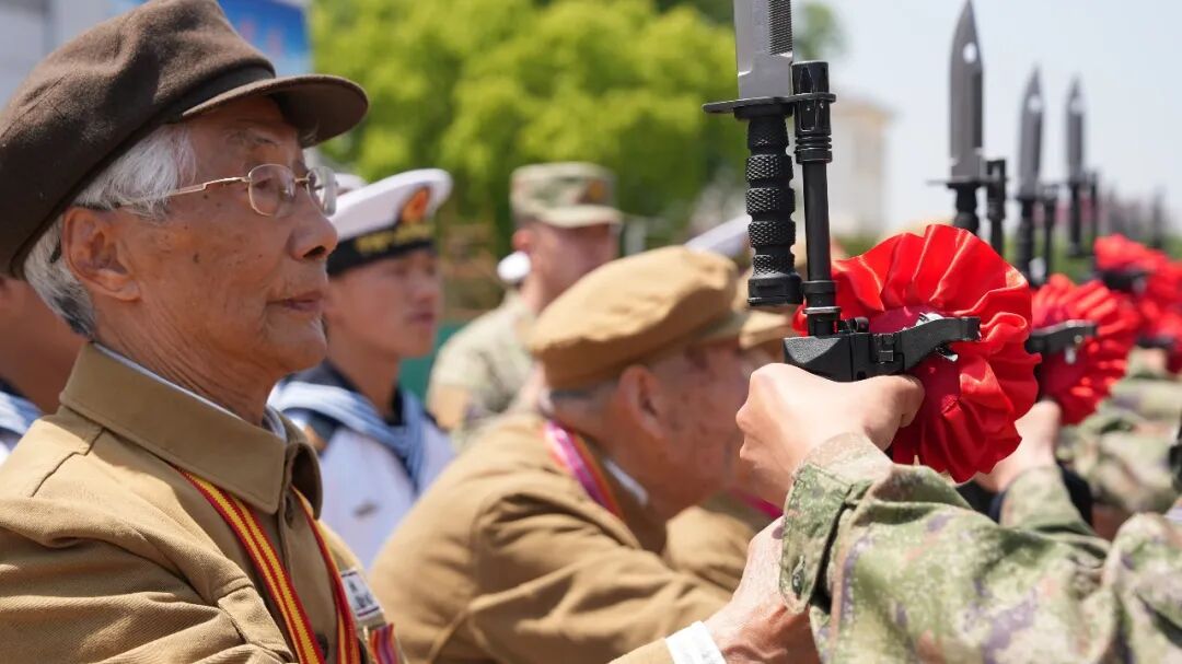 ▲志愿军老战士为列兵授枪