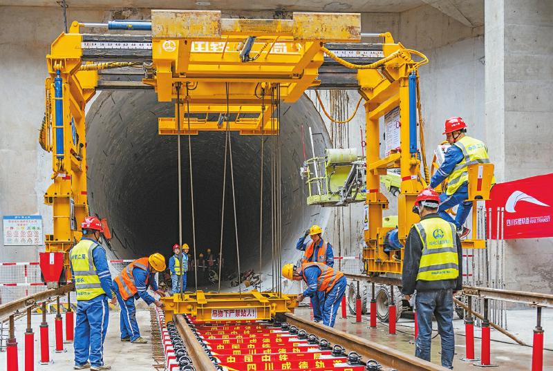 成德线北端德阳北车辆段铺轨基地，工人正在铺设轨排。成都轨道集团供图