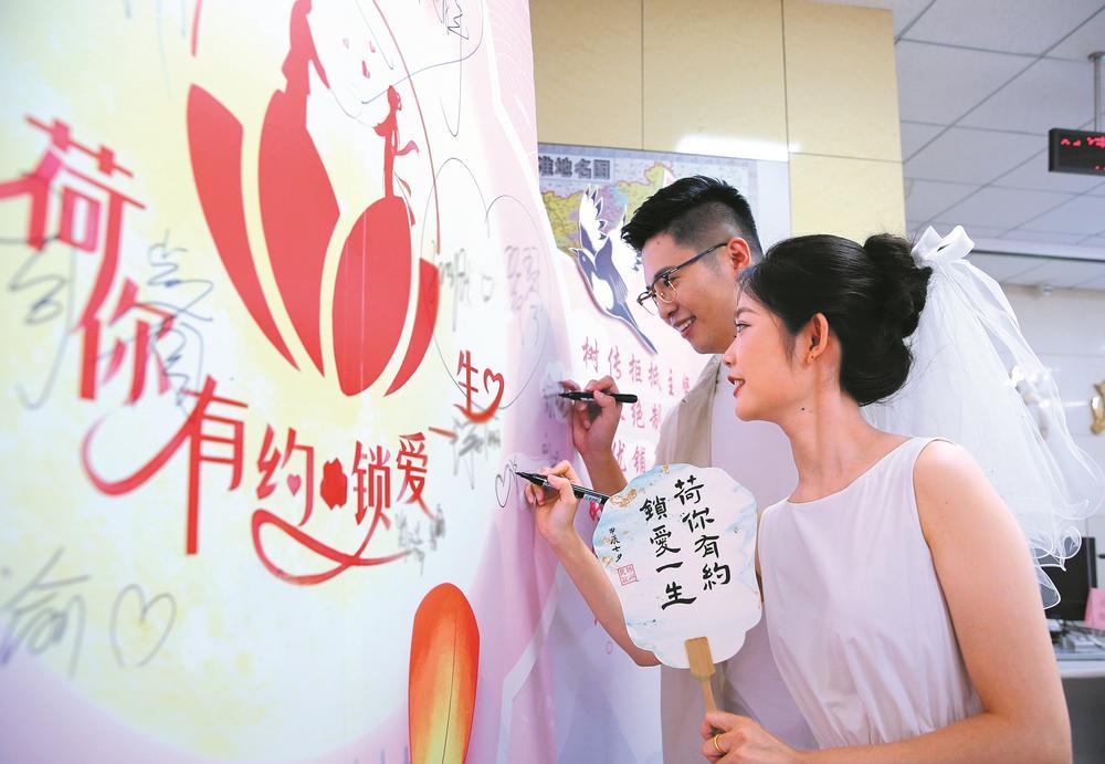 一对新人在民政局婚姻登记处的爱心墙上签名。 新华社记者 李志军 摄
