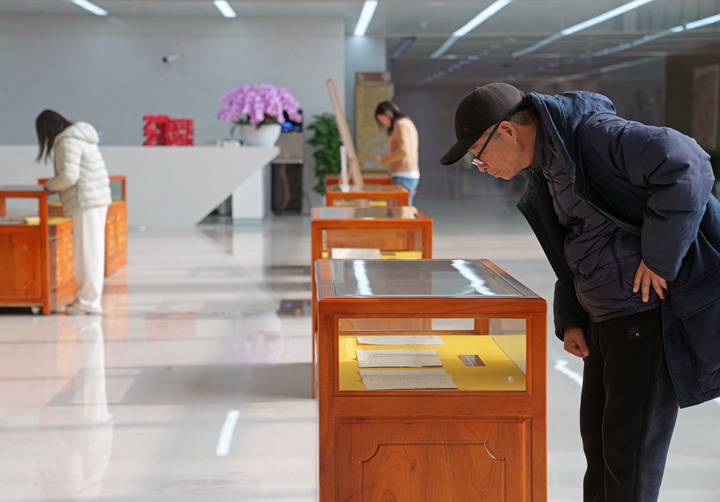 2026年1月6日，参观者在展柜前驻足观看上海市档案馆展出的隐蔽战线工作者红色珍档。新华社记者 刘颖 摄