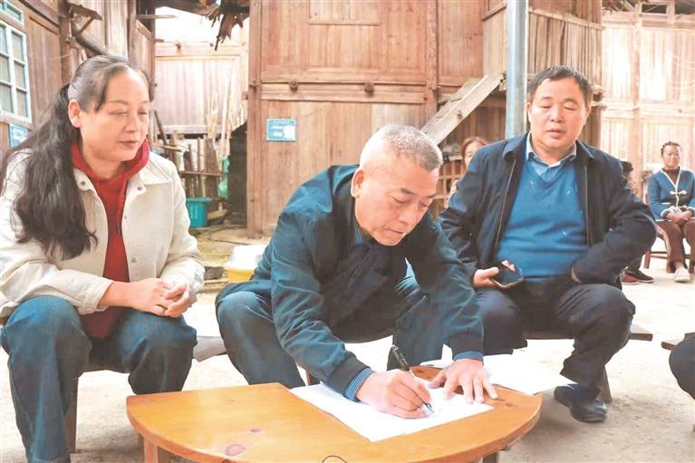 吴才军（中）走访群众。（受访者供图）