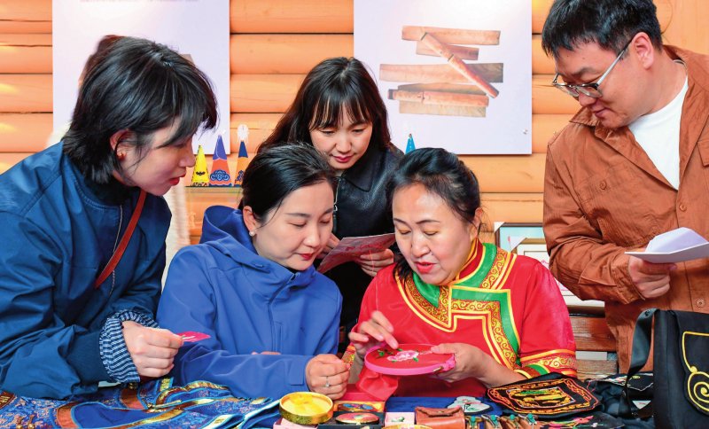 在内蒙古莫力达瓦达斡尔族自治旗，民间艺人为游客展示达斡尔族刺绣技艺（2025年4月28日摄） 新华社发