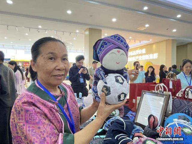 4月24日，壮锦技艺代表性传承人谭湘光展示壮锦文创产品。陈秋霞 摄