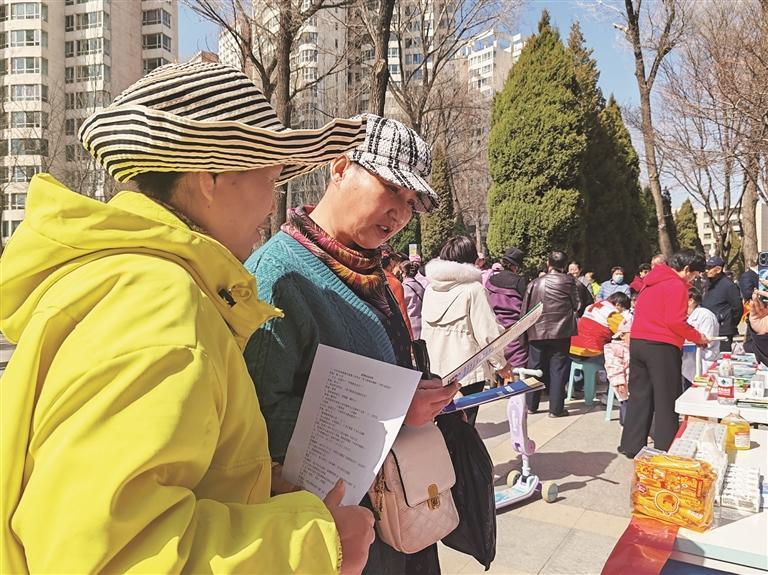 ↓市民仔细阅读建行城北支行发放的宣传手册。西海新闻记者 吴予琴 摄