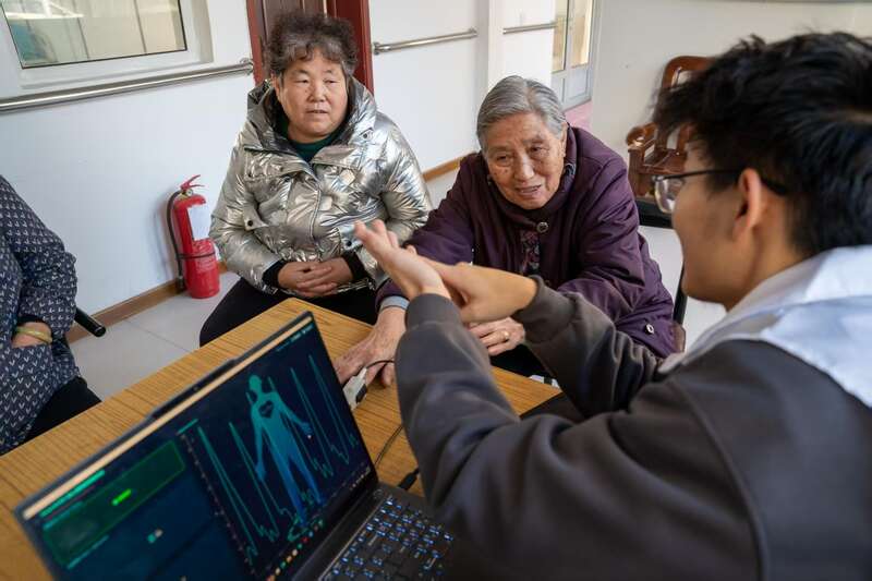 天津大学“有医说医”实践队队员为社区老人做健康筛查。天津大学供图