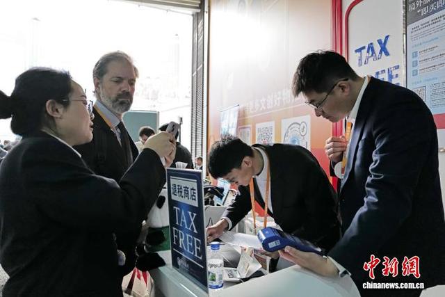 11月9日，在文创馆门口，工作人员协助外籍人员办理离境退税手续。中新社记者 殷立勤 摄