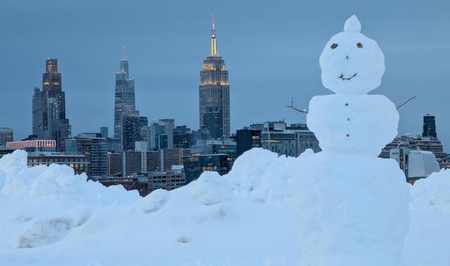 2月23日，美国新泽西州霍博肯，一场暴风雪过后，一个雪人立在公园中，背景是纽约市曼哈顿中城天际线和帝国大厦。视觉中国 图