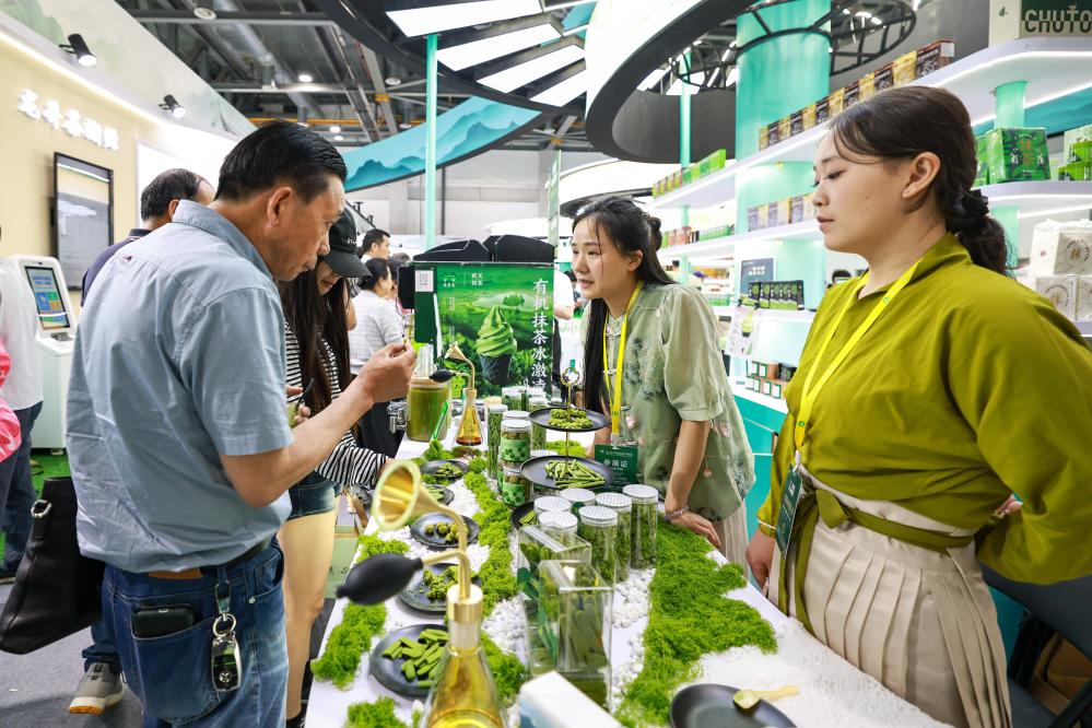 5月21日，观众（左）在茶博会上品尝抹茶产品。新华社记者 江汉 摄