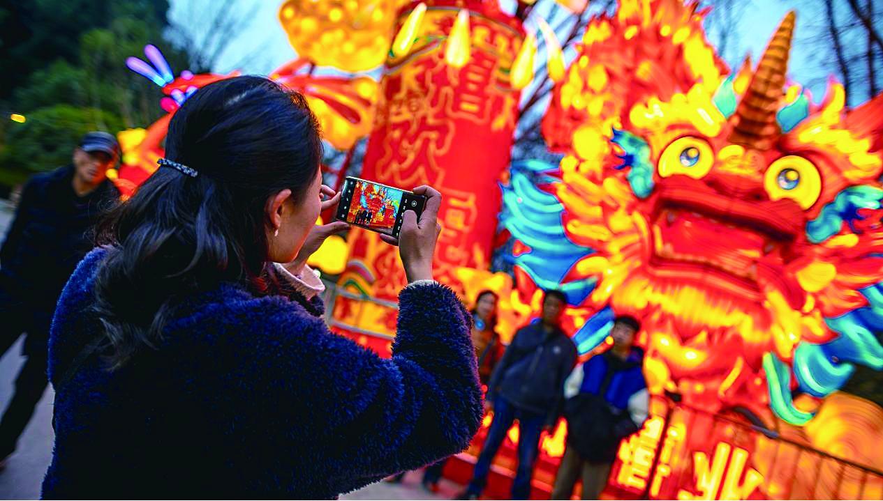 国外游客逛园博园水上灯会，对着灯组拍个不停。