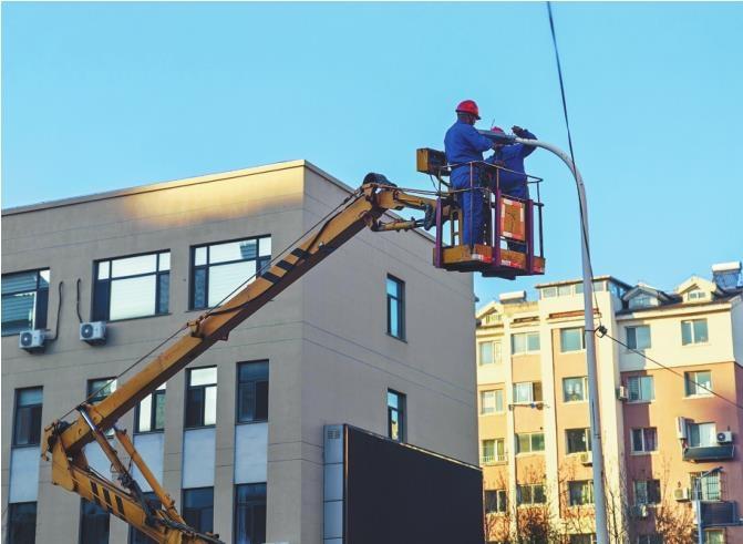 路灯队维修人员正在维修不亮的路灯。本报记者 许刚 摄