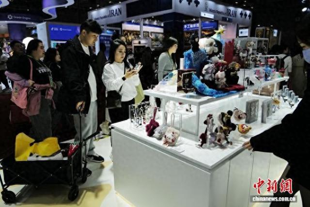 11月9日，第八届进博会上，年轻人纷纷在泡泡玛特展台内拍照分享。 中新社记者 殷立勤 摄