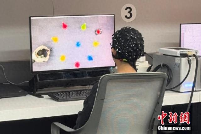 11月19日，天津大学医学院，科研人员正通过脑电信号和屏幕操控无人车避障行驶。高萌 摄