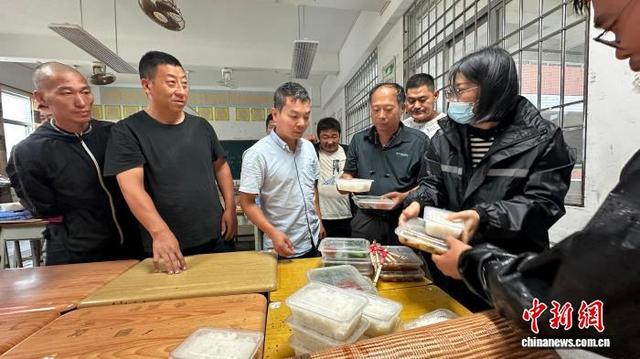 工作人员为滞留安置司乘人员分发盒饭。 郎树臣 摄