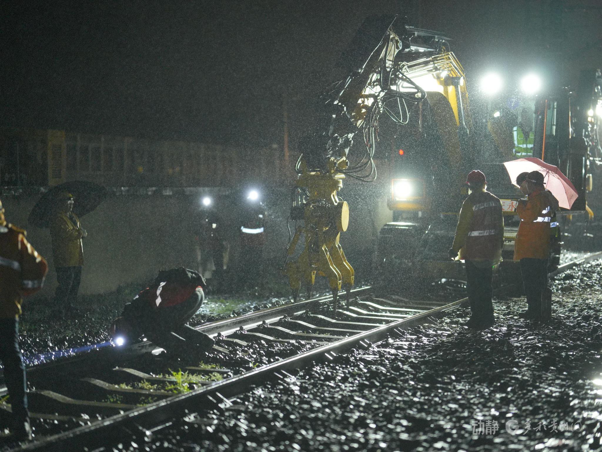 图为3月14日凌晨施工人员利用挖机捣固设备对线路进行捣固作业(吕鹏程摄)