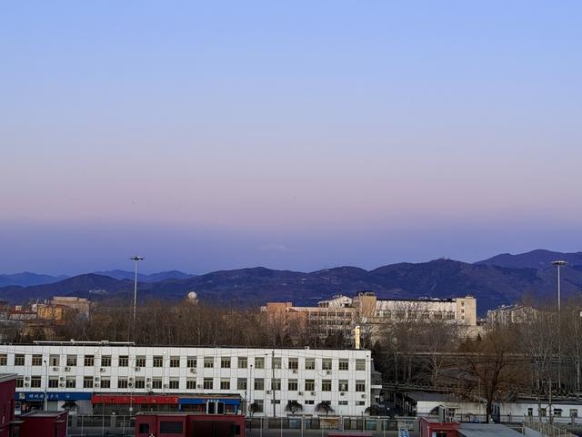 沙尘退去，西山沐浴在粉色早霞中。 温红征 摄