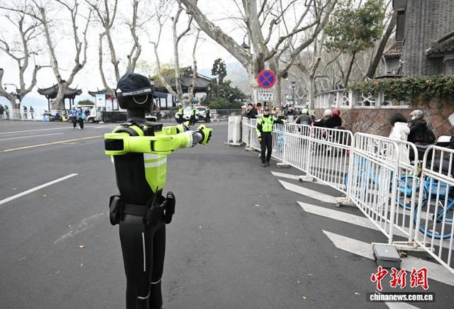 3月22日，AI交管机器人在西湖断桥马拉松赛道附近指挥交通。中新社记者 王刚 摄